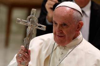 Pope Francis blesses with a crucifix during an audience with people who have autism in Paul VI hall at the Vatican Nov. 2014. 
