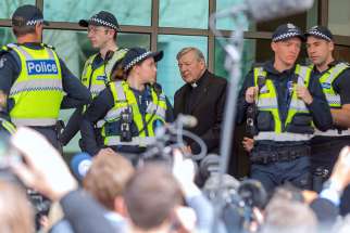 Vatican Treasurer Cardinal George Pell is surrounded by Australian police and members of the media as he leaves the Melbourne Magistrates Court in Australia on July 26, 2017.