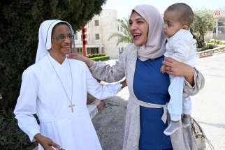 Sister Aleya Kattakayam, a member of the Sisters of Charity, greets Ayah Issa, 32, and her 18-month-old son Ahmad, outside Caritas Baby Hospital in Bethlehem, West Bank, April 27, 2024.