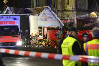 Rescue workers inspect the scene where a truck crashed into a Christmas market in Berlin Dec. 19. The terrorist attack killed at least a dozen people and injured nearly 50 as it smashed through tables and wooden stands.