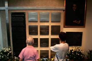 Visitors look at the names of six Jesuits killed during El Salvador’s civil war in the chapel of Central American University in San Salvador. The priests, their housekeeper and her daughter were killed Nov. 16, 1989.