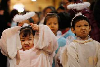 Children dressed as angels react as they attend Christmas Mass at a Catholic church Dec. 24.
