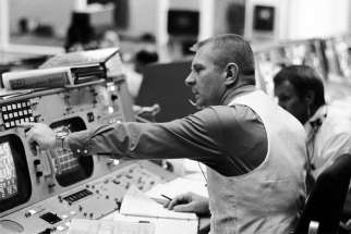 Flight director Gene Kranz is seen seated at his console in the mission operations control room in the Manned Spacecraft Center&#039;s Mission Control Center in Houston the launch of the Apollo 11 lunar landing mission July 16, 1969. Partially visible in the background is flight director Gerald D. Griffin. Kranz is a parishioner at Shrine of the True Cross Catholic Church in Dickinson, Texas, near Houston.