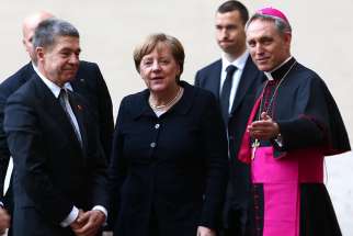 Archbishop Georg Ganswein greets German Chancellor Angela Merkel and her husband, Joachim Sauer, at the Vatican March 24. Amid rising unrest and influx of refugees, some ordinary Germans feel their concerns are being ignored by the Church and the government.