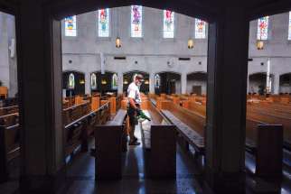An electrostatic disinfectant is applied to the pews at Christ the King Church in Nashville, Tenn. Bishop J. Mark Spalding has reinstated public Masses in the diocese at the discretion of pastors.