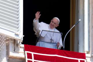Pope Francis greets the crowd as he leads the Angelus from the window of his studio overlooking St. Peter&#039;s Square at the Vatican Aug. 18, 2019.