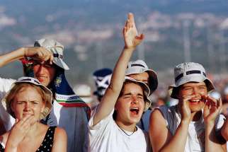 Young people react as the helicopter carrying Pope John Paul II lands at the site of the 2000 World Youth Day prayer vigil outside Rome. He inaugurated World Youth Day 30 years ago. Its international gatherings have drawn hundreds of thousands of people.