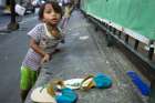 A girl leans against a wall on the streets of Manila, Philippines, Jan. 14.