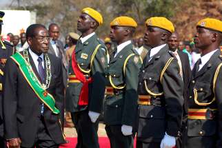 Zimbabwe President Robert Mugabe inspects soldiers in 2007 in Harare. Church leaders in Zimbabwe called for calm and for an interim government after the military seized power Nov. 15. 
