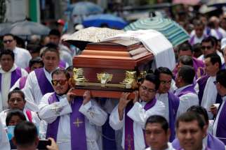 Priests carry the casket of Father Cecilio Perez Cruz during his funeral procession in Sonzacate, El Salvador, May 20, 2019. Parishioners found Father Perez dead in his residence in Juayua early May 18 with a note nearby that said he had not paid &quot;rent,&quot; a euphemism for extortion money.
