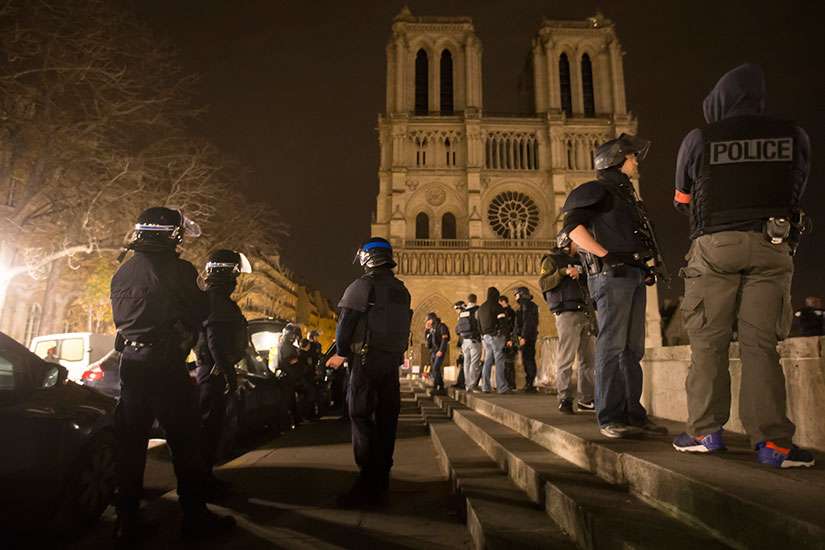 Armed police officers go on foot patrol around Notre Dame Cathedral in Paris Nov. 14. Dozens of people were killed in a series of attacks in Paris Nov. 13.