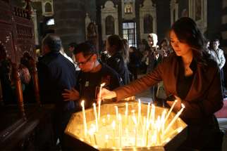 A woman lights a candle on Good Friday in 2015 in Damascus, Syria. Christians in the Middle East, particularly those who have been forced from their homes by violence and persecution, need the support of the Catholic Church, a Vatican official said. 