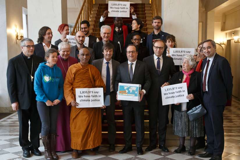 French President Francois Hollande holds a box containing an international petition to support the climate talks as he poses with religious leaders Dec. 10 at the Elysee Palace in Paris. Nearly 2 million people of faith have petitioned for a fair climate change agreement that would stop global warming and protect the poor, reported religious groups in Paris for the U.N. climate change conference. 