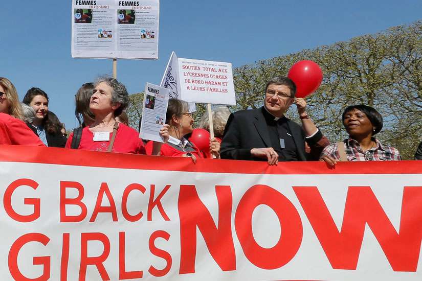 A clergyman joins others in a &quot;Bring Back Our Girls&quot; gathering in Paris April 14. A year after more than 200 Nigerian schoolgirls were kidnapped, Lagos Cardinal Anthony Olubunmi Okogie said he believed that &quot;God will answer our prayers&quot; for their return. 