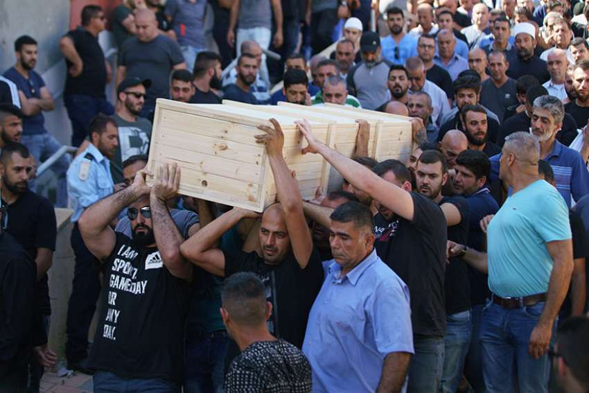 Men carry the casket of Israeli policeman Hail Sethawi July 14 who was killed in an attack at the Temple Mount compound in the Old City of Jerusalem. The deadly attack took place in the early morning hours near the Lions&#039; Gate in the Old City walls, next to what Muslims call the Noble Sanctuary and Jews call the Temple Mount.