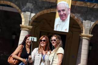 Tourists take a &quot;selfie&quot; in front of an image of Pope Francis in Havana Sept. 18, the eve of his visit to Cuba.