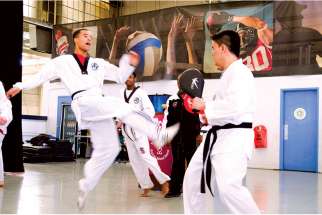 Adam Tomlinson demonstrates his taekwondo technique before about 500 students at the Toronto Catholic District School Board’s Pan Am Celebration Day.
