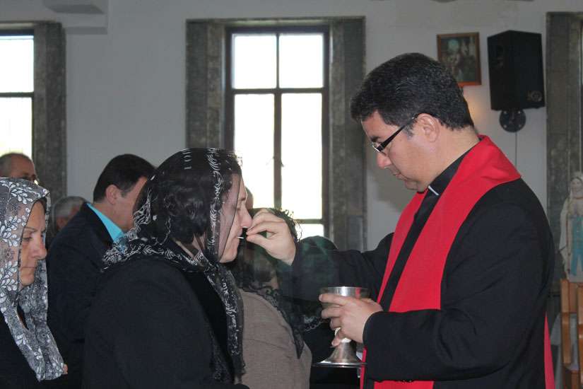 Bishop Oscar Cantu of Las Cruces, N.M., distributes Communion to displaced Iraqi Christians during a Jan. 20 visit to northern Kurdistan. Bishop Cantu traveled to northern Iraq with a delegation from the U.S. Conference of Catholic Bishops Jan. 16-20 to see the needs of displaced Christians and other religious minorities. 