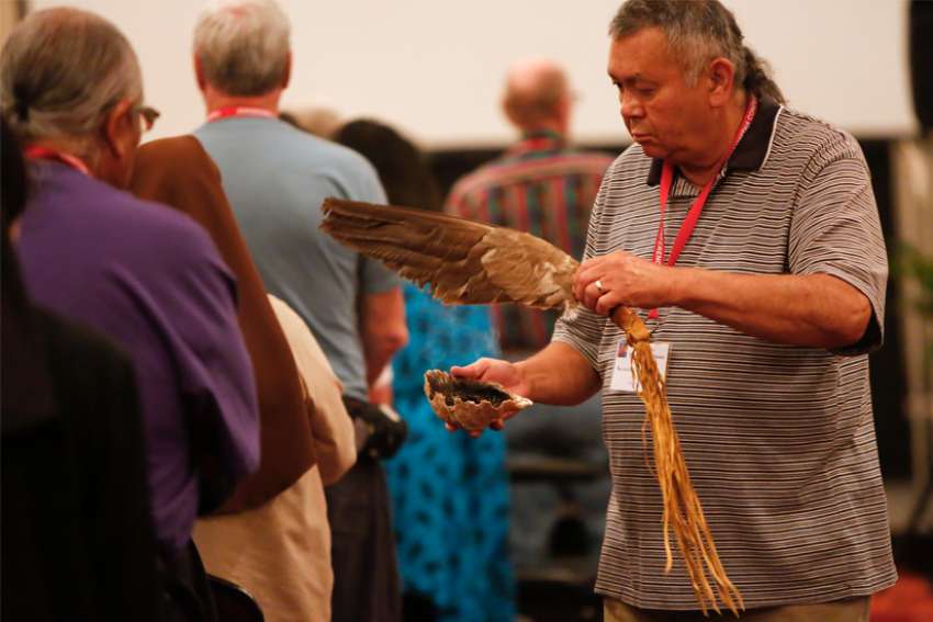 Ken Perrault of Minnesota, an Ojibwe, conducts a purification ritual called &quot;smudging&quot; at the start of a Mass during the Tekakwitha Conference in Fargo, N.D., in this July 25, 2014, file photo.