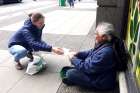 A volunteer with Catholic Street Missionaries interacts with a homeless man in Vancouver.