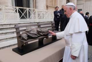 Pope Francis blesses a smaller sculpture of Homeless Jesus created by Timothy Schmalz in 2013. The life-sized sculpture has found another home on the steps of the papal charities.