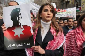 Jordan&#039;s Queen Rania holds a picture of First Lt. Muath al-Kasasbeh, executed Jordanian pilot, during a Feb. 6 march in Amman. As Jordan steps up airstrikes on Islamic State targets in Syria to avenge the murder, Catholic and other leaders are hoping tha t the tragedy can still yield good for the future. 