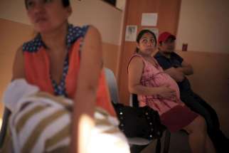 A pregnant woman waits to be seen Jan. 29 at the Women&#039;s National Hospital in San Salvador, El Salvador. Health officials have urged women to postpone their pregnancies for two years, because the Zika virus can produce microcephaly, a rare neurological condition that causes smaller heads in newborns, affecting the normal development of their brain.