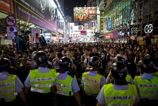 Riot police faceoff with pro-democracy protesters at Mongkok shopping district in Hong Kong Nov. 26, 2014. 