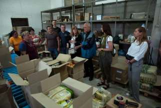 CNEWA’s Adriana Bara (fourth from right), Msgr. Peter Vaccari and Anna Dombrovska (second from right) visit volunteers packing supplies as part of the Food Boxes for Ukraine initiative.