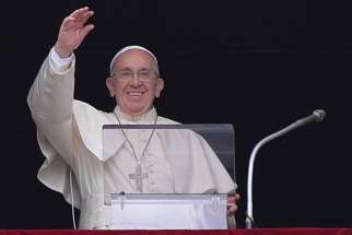 Pope Francis waves to faithful and tourists during his Angelus prayer at the Vatican, Aug. 16. 