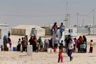 Syrian refugees collect water at the Zaatari refugee camp near Mafraq, Jordan, Aug. 18, 2016.