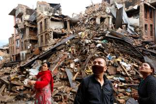 Survivors look at destroyed buildings April 27 following an earthquake in Bhaktapur, Nepal. More than 3,600 people were known to have been killed and more than 6,500 others injured after a magnitude-7.8 earthquake hit a mountainous region near Kathmandu April 25. 