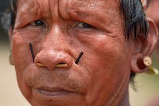 His face painted red with urucum, a man participates in a march by indigenous people through the streets of Atalaia do Norte in Brazil&#039;s Amazon region March 27, 2019. Existing formation programs are not preparing priests and other pastoral workers to be leaders in a church with an Amazonian and indigenous face, according to bishops participating in the Synod of Bishops for the Amazon.