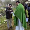 Father Ibrahim Shomali gives Communion to Martin Rau of Germany during an outdoor Mass in an olive grove outside the Salesian Monastery in Beit Jalla, West Bank, Jan. 18. A planned routing of the Israeli separation barrier could isolate the monastery fro m the people it serves.