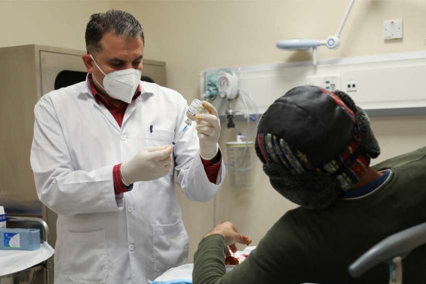 Dr. Mohammad Arrad, a Syrian refugee, attends to a patient at a public hospital in Amman, Jordan, in this Dec. 9, 2021, file photo. In a message for the Feb. 11 World Day of the Sick, Pope Francis emphasized a patient-centered approach to medical care.