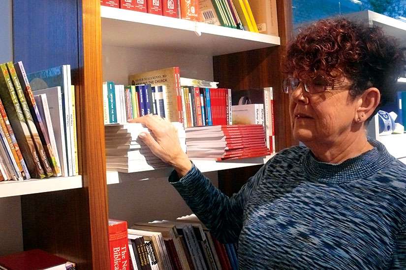 Manager Shirley Kulmatycki scans some of the packed shelves in the Newman Theological College Bookstore in Edmonton.