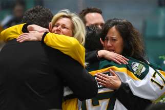 Mourners embrace during an April 8 vigil at Elgar Petersen Arena in Humboldt, Saskatchewan, to honor members of the Humboldt Broncos junior hockey team who were killed in a fatal bus accident.