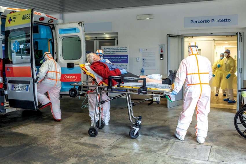 Medical workers at Gemelli Hospital in Rome wear protective suits as they attend an elderly coronavirus patient.