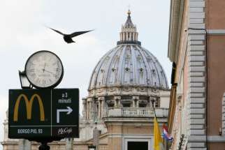 A sign in front of St. Peter&#039;s Basilica points to the newest McDonald&#039;s restaurant in Rome, next to the Vatican. Jan. 3, 2017.