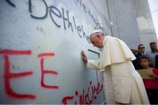 Pope Francis prays for peace in front of the Israeli security wall in Bethlehem, West Bank, May 25, 2014. The unscheduled stop was a highlight of the pope&#039;s three-day trip to the Holy Land.
