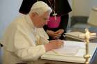 Pope Benedict XVI signs a copy of his encyclical, &quot;Caritas in Veritate&quot; (&quot;Charity in Truth&quot;), at the Vatican July 6, 2009.
