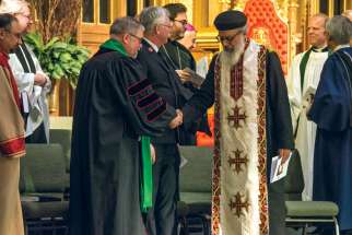Rev. Dr. Peter Holmes, left, offers the sign of peace to Orthodox Coptic Fr. Bishoi Wasfy at a service to wrap up the Week of Prayer of Christian Unity held at St. Michael’s Cathedral Basilica Jan. 29.