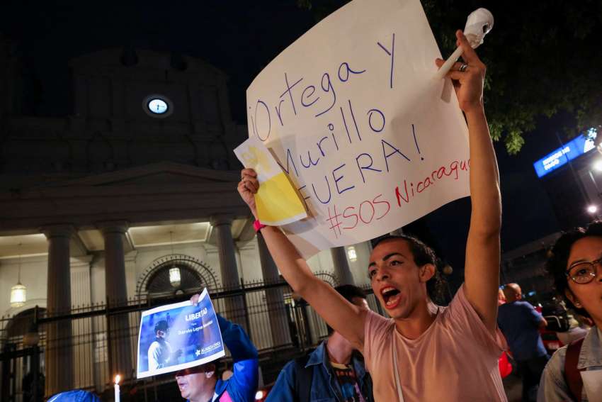 A Nicaraguan exiled in Costa Rica holds up a sign reading: &quot;Ortega and Murillo Out! #SOSNicaragua&quot; during the &quot;Vigil of Faith and Freedom&quot; outside the Metropolitan Cathedral in San Jose, Costa Rica, Aug. 19, 2022, to protest against the detention of Nicaraguan Bishop Rolando Álvarez of Matagalpa, by Nicaraguan authorities. The Nicaraguan regime extinguished the Jesuits&#039; legal status Aug. 23, 2023, and said it will expropriate its assets, effectively making it illegal for the Society of Jesus to operate in the Central American country.