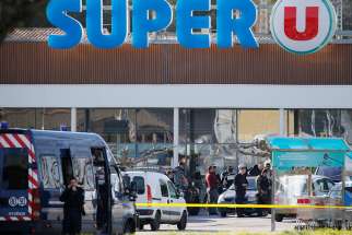 French police officers and investigators are seen March 23 at a supermarket after a hostage situation in Trebes. Pope Francis joined leaders praising a French police officer who &quot;gave his life out of a desire to protect people&quot; during a terrorist attack.