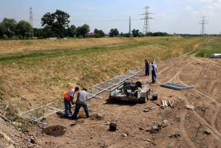 Workers install security barriers at the site of Campus Misericordiae in Brzegi, Poland June 15.