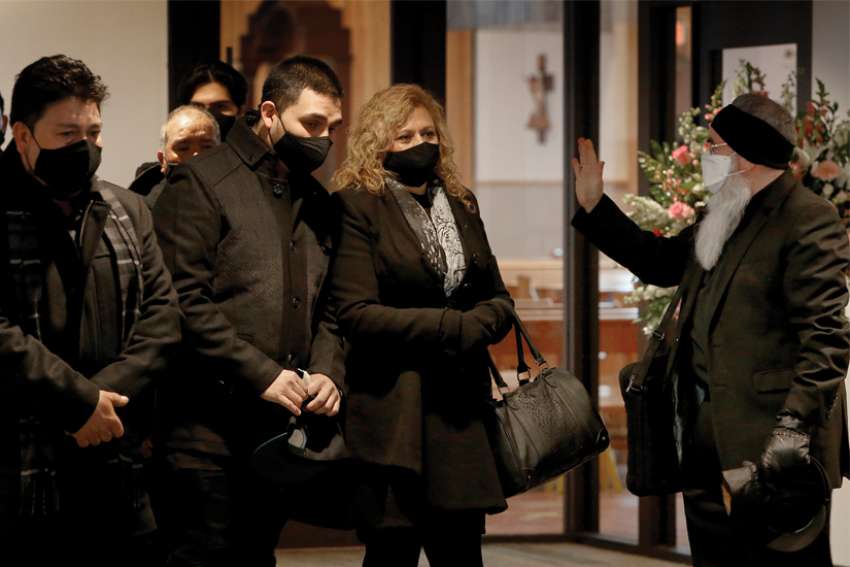 A priest gives a blessing following a funeral Mass.