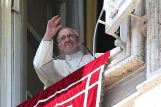 Pope Francis waves as he leads the Angelus from the window of his studio overlooking St. Peter&#039;s Square June 25 at the Vatican.