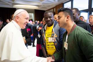 Pope Francis greets a youth delegate before a session of the Synod of Bishops on young people, the faith and vocational discernment at the Vatican Oct. 4.