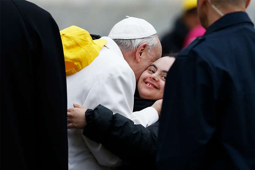 Pope Francis embraces a young woman as he meets the sick and people with disabilities during his general audience in St. Peter&#039;s Square at the Vatican April 4.