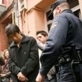 A policeman escorts a man detained during a 2009 raid on a human trafficking operation near Barcelona, Spain.